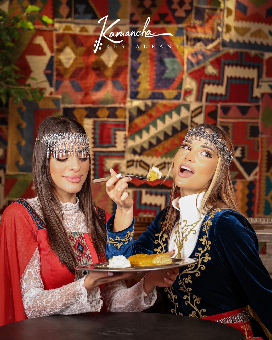 Guests in traditional Armenian dress before the kilim wall at Kamancha