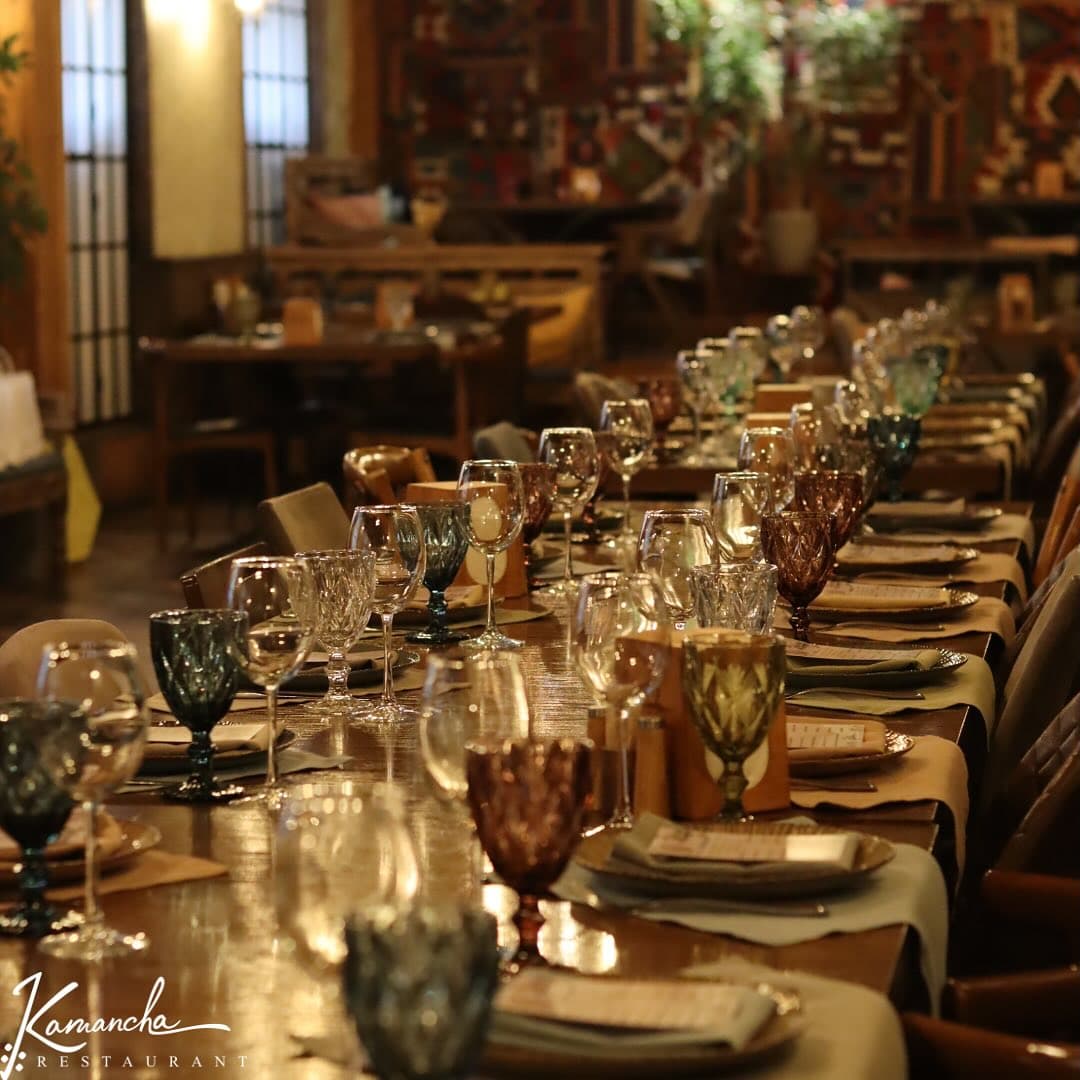 A long table laid with colored glassware before service